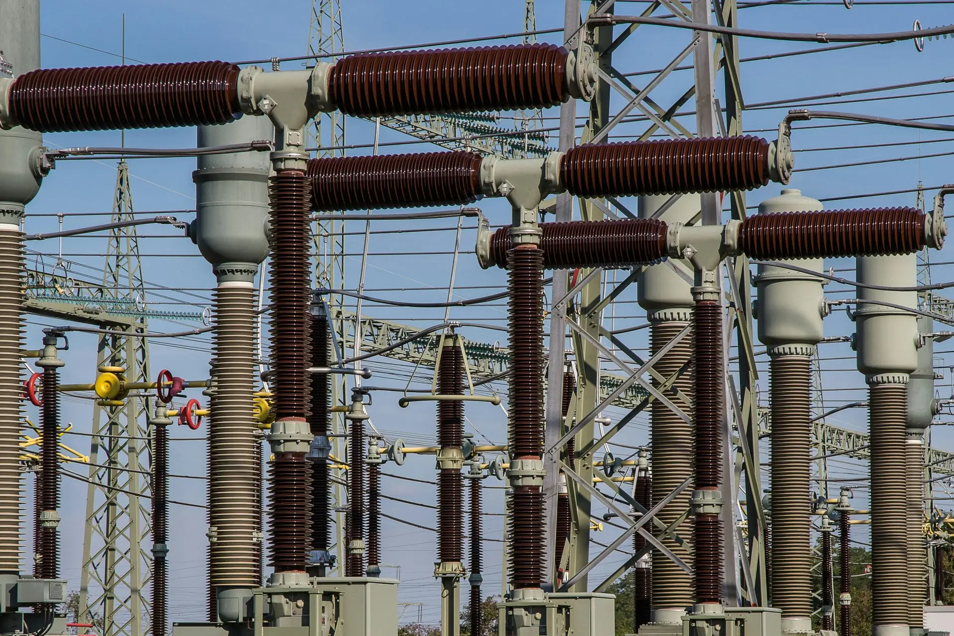 Detailed view of high voltage electrical substation with transformers and power lines.